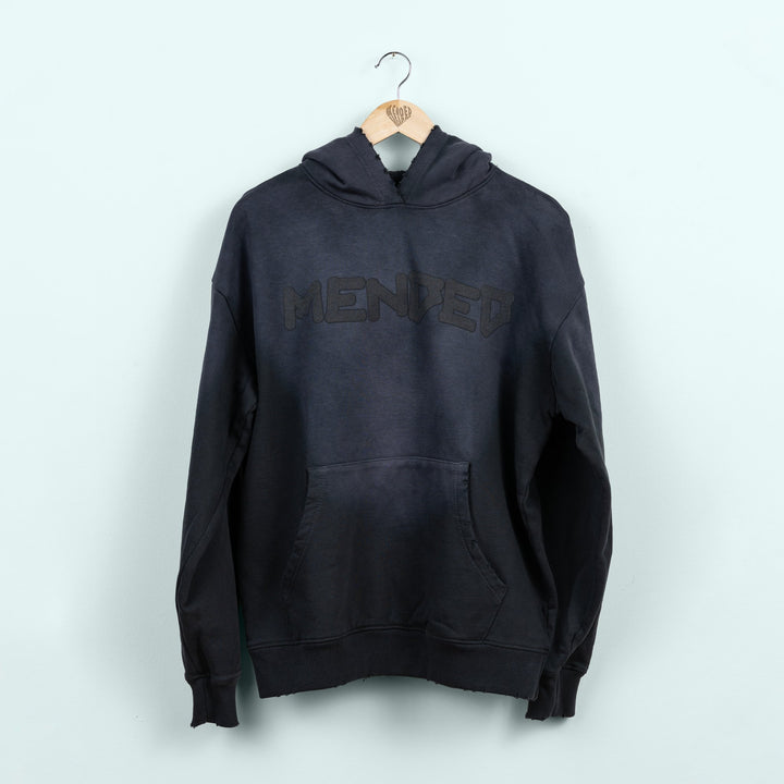 Black hoodie with 'MENDED' branding on a white background