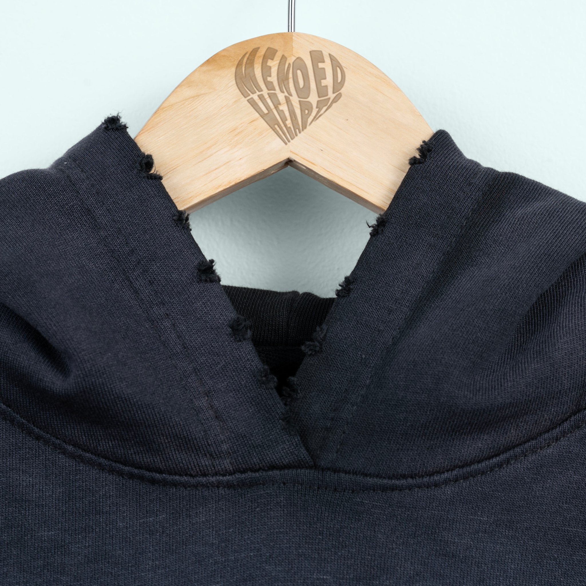 Navy blue garment on a hanger with 'MENDED HEARTS' branding.