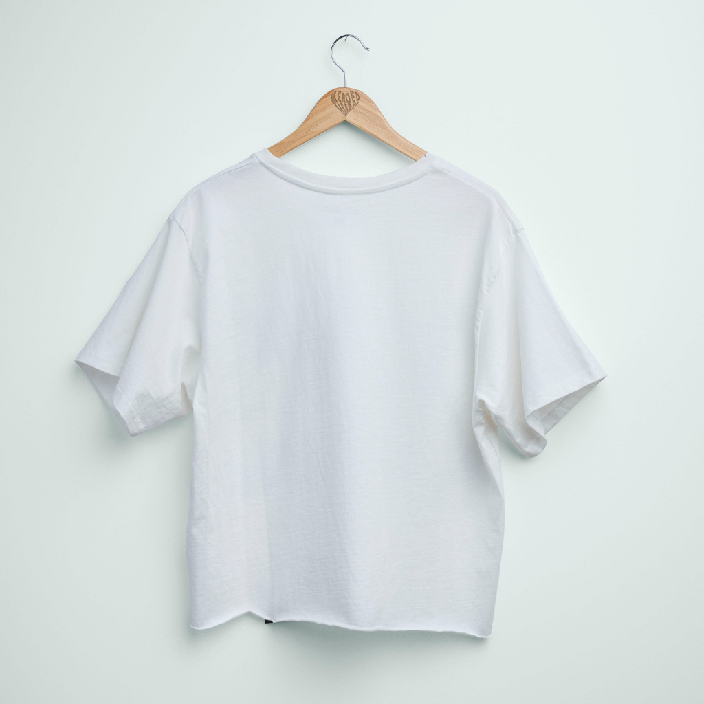 White t-shirt on a wooden hanger against a light gray background