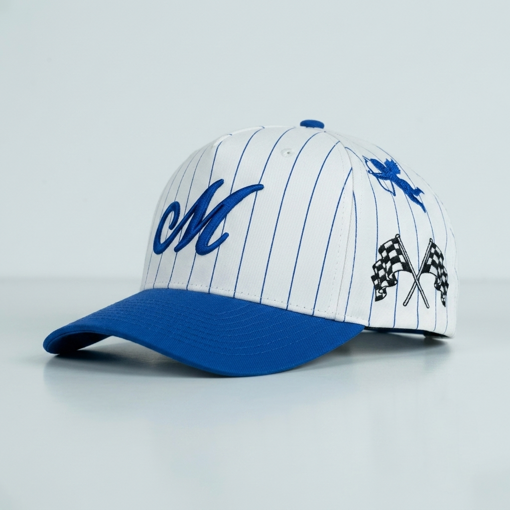 A white baseball cap with blue pinstripes, a blue visor, a blue script 'M' on the front, a blue maple leaf on the side, and black-and-white checkered flags on the other side.