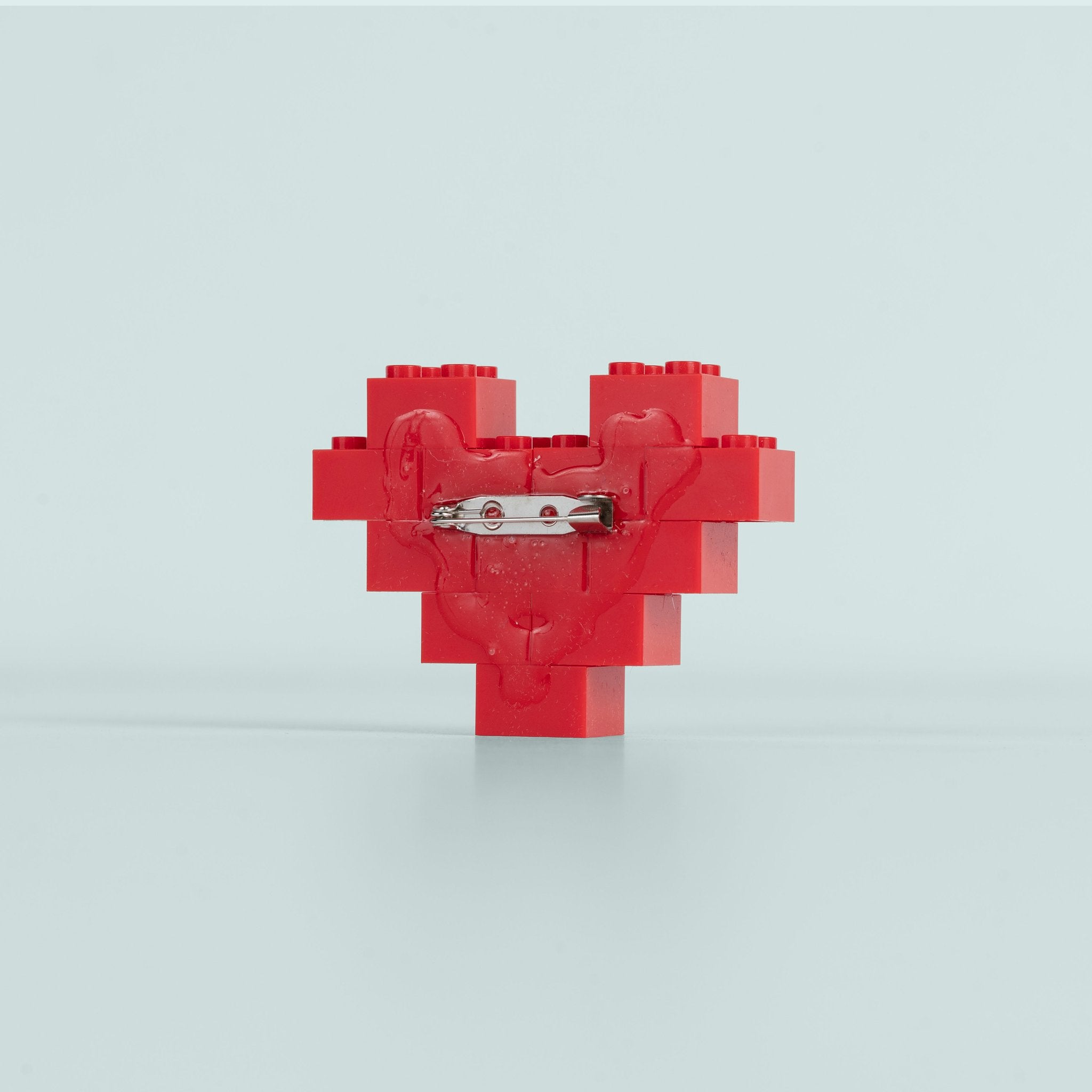 Red pixelated heart-shaped object on a light gray background
