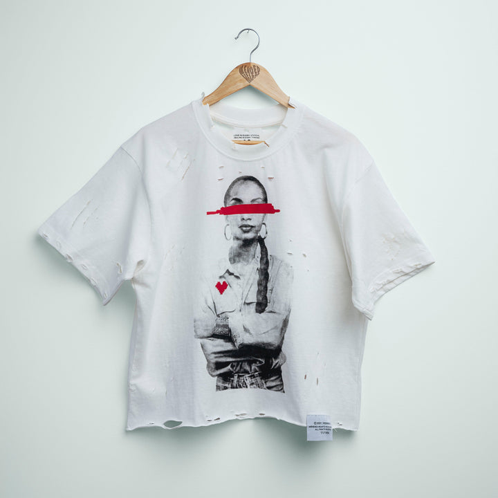 White t-shirt with graphic design on a hanger against a light gray background