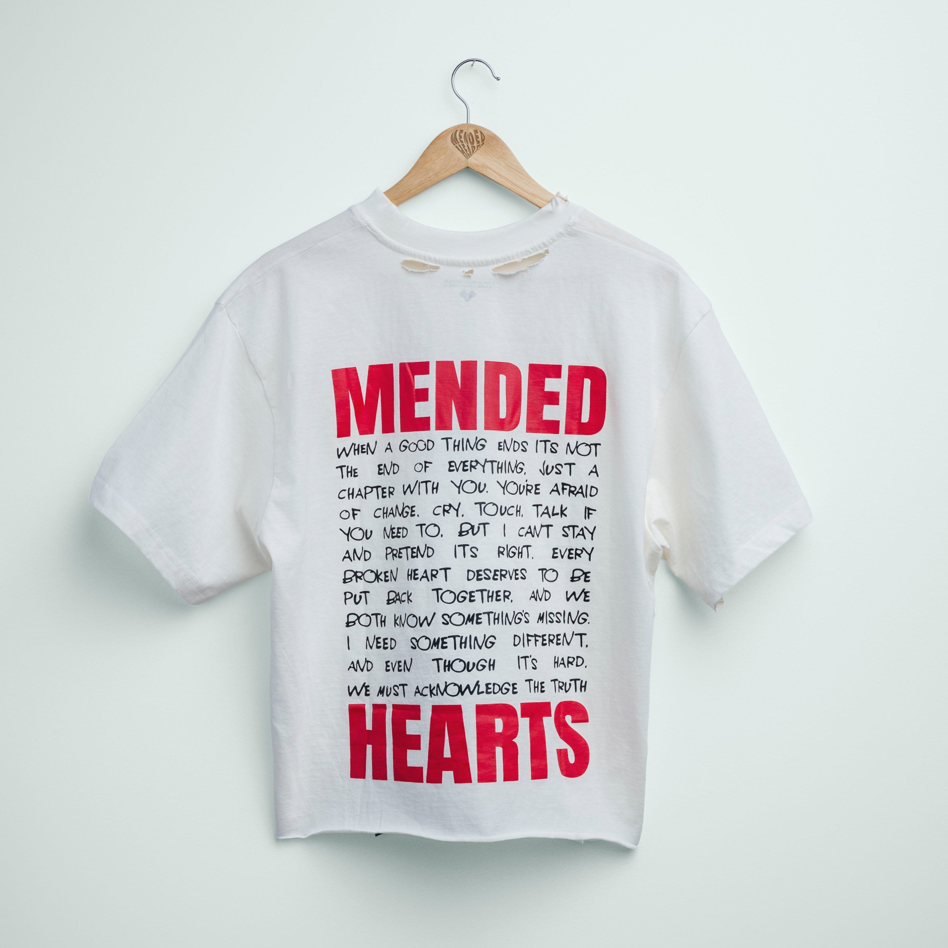 White t-shirt with red and black text on a hanger against a white background